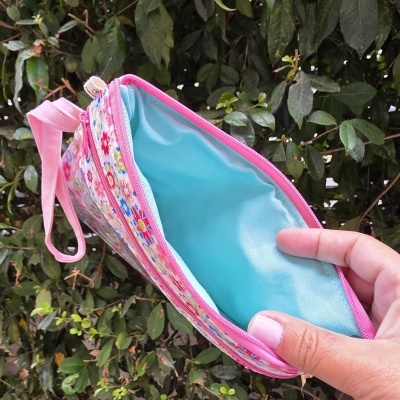 Necessaire pequena com padrão floral e interior azul clara