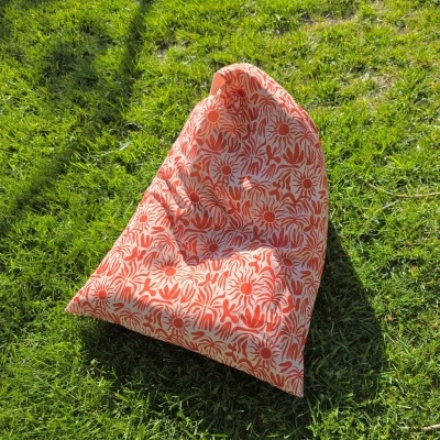 Pufe floral vermelho e branco sobre relva verde