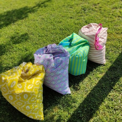 Quatro sacos de tecido coloridos com diferentes padrões sentados na relva