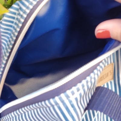 Bolsa azul com riscas brancas, alça azul escura e interior azul
