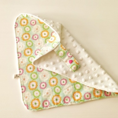 Fralda colorida de tecido com padrão floral e relevo branco