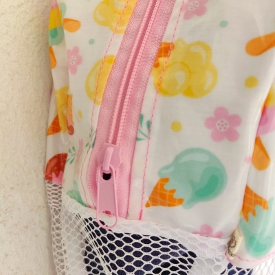 Mochila colorida com padrão de nuvens, flores e gelados e fecho rosa