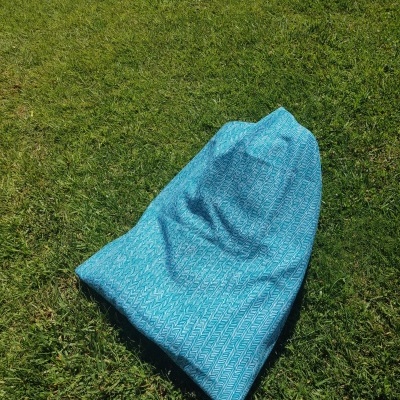 Saco azul claro com padrão geométrico branco na relva