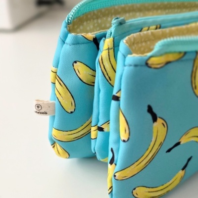 Três bolsas azuis com padrão de bananas amarelas