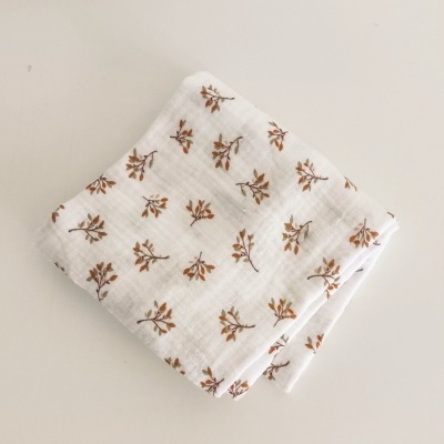 Manta ou pano de tecido branco com padrão floral castanho e verde