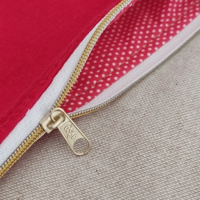 Necessaire vermelha com interior de bolinhas brancas e fecho dourado