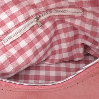 Interior de bolsa rosa com forro xadrez rosa e branco e fecho de correr