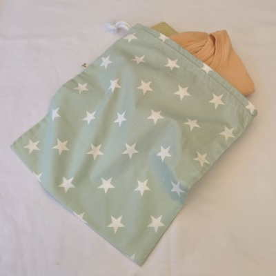 Saco verde com estrelas brancas com roupas cor de pêssego e verde