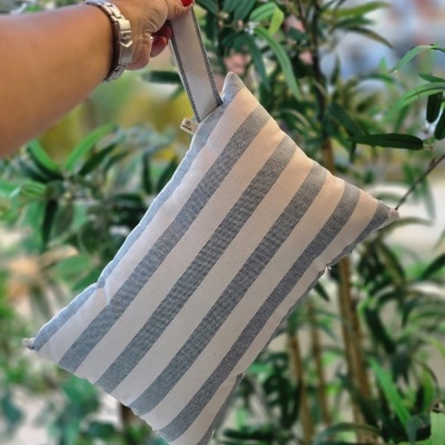 Bolsa de tecido com riscas azuis e brancas pendurada em mão
