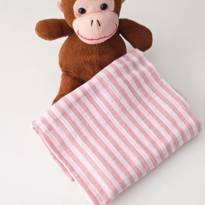 Boneco de peluche castanho com manta às riscas cor de rosa e branca