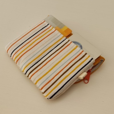 Carteira de tecido com riscas coloridas e fecho de correr vermelho