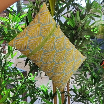 Mala pequena com padrão geométrico amarelo e branco com alça verde