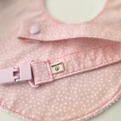 Babete rosa com pontos brancos, fecho lilás e etiqueta Gutermann
