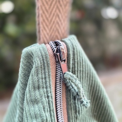 Mala verde com fecho de correr metálico e alça em tecido castanho