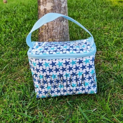 Mala térmica quadrada com padrão de estrelas azuis e brancas e alça azul