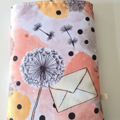 Almofada decorativa em tecido com estampa de dente-de-leão, bolinhas e envelope