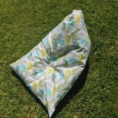 Pufe de tecido com padrão de folhas sobre relva