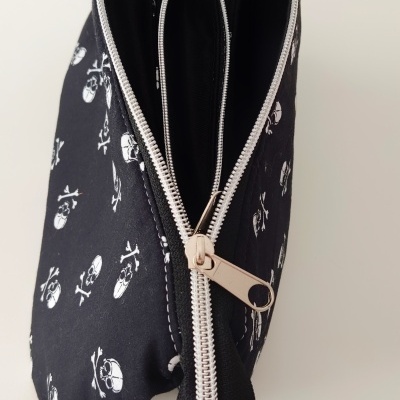 Bolsa preta com estampado de caveiras e fecho prateado