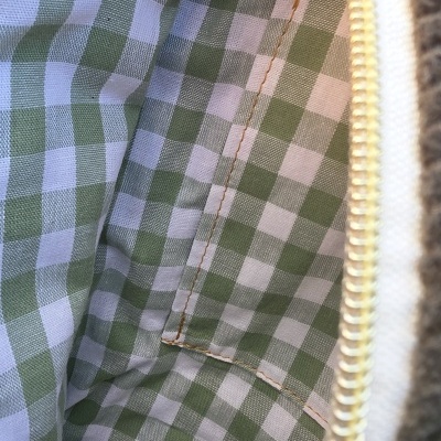 Interior de carteira ou bolsa xadrez verde branco com fecho zip bege e puxador dourado