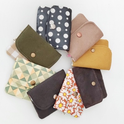 Conjunto de nove capas pequenas coloridas com diferentes padrões e botões frontais.