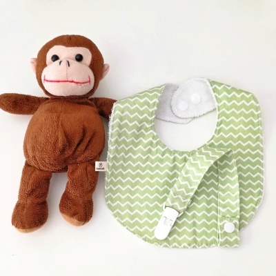 Pelúcia macaco castanho e babete verde padrão ondas com fecho e prendedor