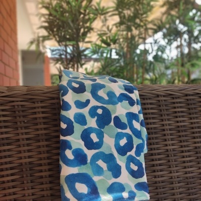 tecido azul e branco com padrão de manchas sobre cadeira de vime