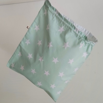 Saco têxtil verde claro com estrelas brancas pendurado