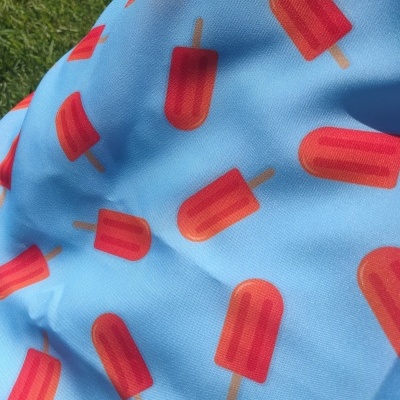Tecido azul com padrão de gelados vermelhos em fundo verde