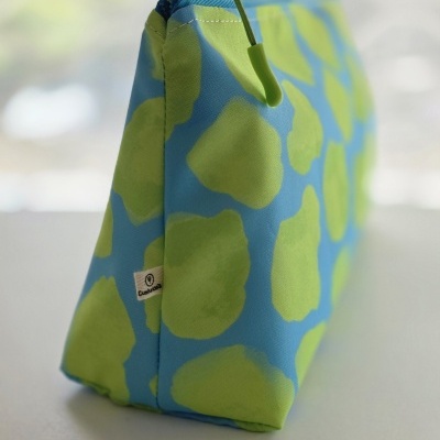 Bolsa de tecido azul com padrão verde e fecho de correr