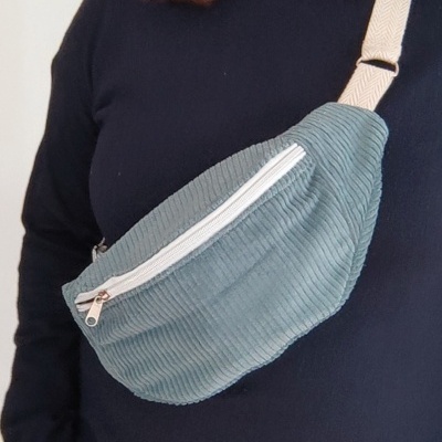 Bolsa tipo pochete azul claro em veludo cotelê com fecho branco e alça branca