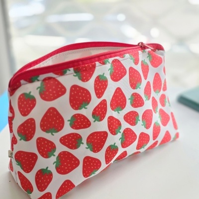 Necessaire com padrão de morangos vermelhos e fecho vermelho