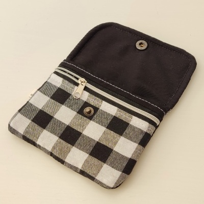 Carteira quadriculada em preto e branco com fecho botão e fecho éclair