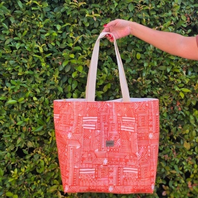 Mala tote coral com padrão geométrico e alças bege