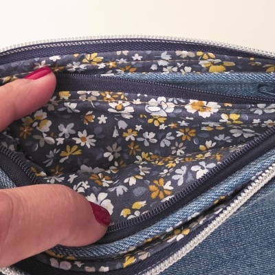 Bolsa em tecido jeans azul com interior floral azul escuro e fechos