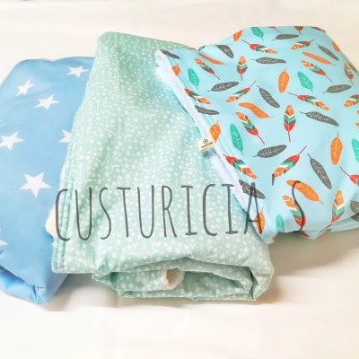 Três tecidos dobrados com padrões diferentes, sobre superfície branca