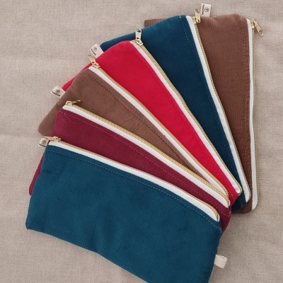 Conjunto de bolsas coloridas com fechos dourados sobre superfície bege