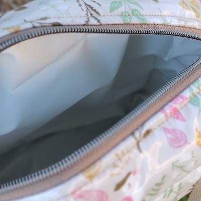 Bolsa pequena com padrão floral colorido e fecho de correr aberto