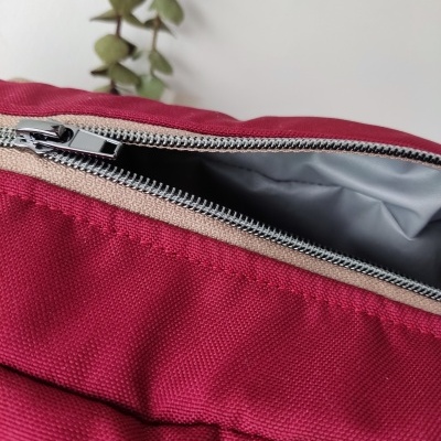 Mala vermelha com fecho metálico aberto e interior cinzento