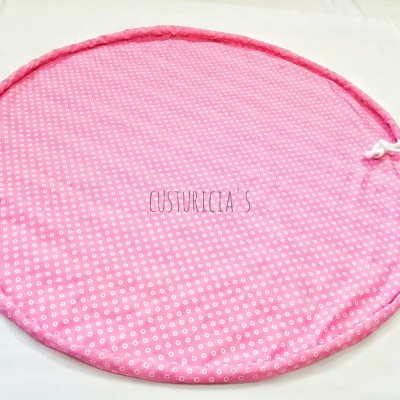 Tapete redondo cor-de-rosa com padrão de pequenos círculos brancos e borda almofadada