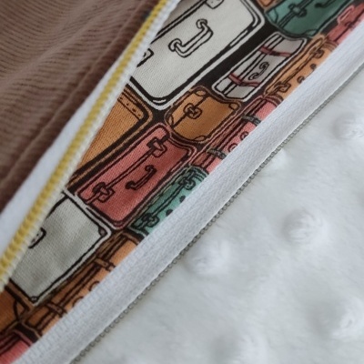 tecido com padrão de malas coloridas com fecho aberto sobre superfície branca texturizada