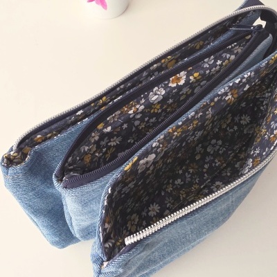 Bolsa azul com interior floral e vaso com planta e flores roxas