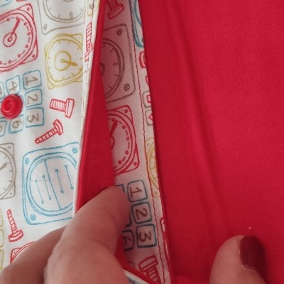 Caderno com capa de tecido branco estampado com relógios coloridos e interior vermelho liso