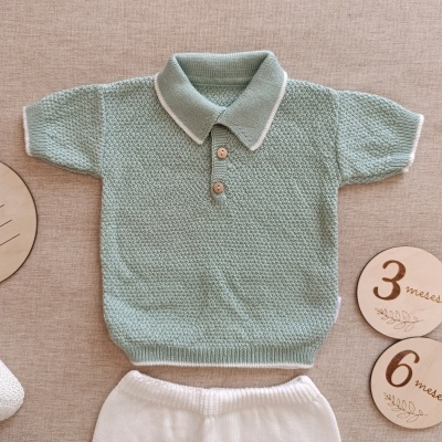 Conjunto de roupa para bebé em malha verde clara e branca com discos de madeira ao lado
