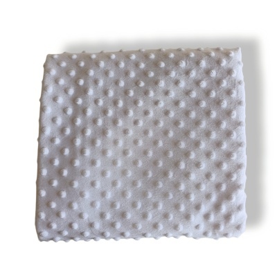 Cobertor branco com bolinhas em relevo dobrado