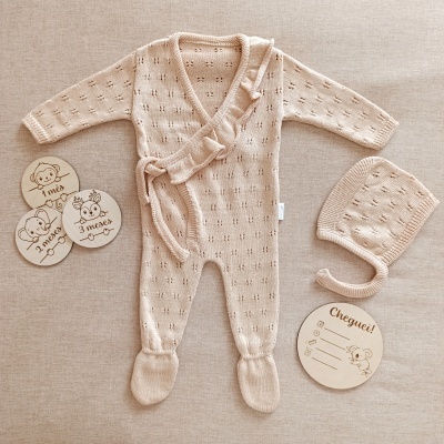 Macacão e gorro de bebé bege com placas de madeira com meses e chegada
