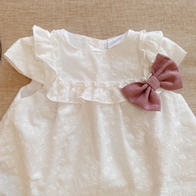 Vestido branco de bebé com bordados florais e laço rosa