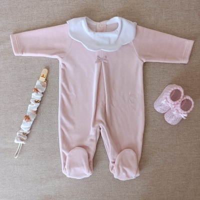 Conjunto bebé com babygrow rosa, gola branca, prendedor de chucha e sapatinhos rosa tricotados.