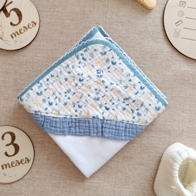 Toalha para bebé com capuz estampado, fundo bege e elementos em madeira gravada