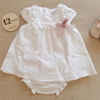 Vestido branco com folhos e laço cor de rosa para bebé.