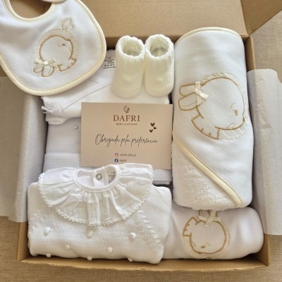 Conjunto de roupa branca para bebé com bordados dourados de coelho e acessórios numa caixa de cartão